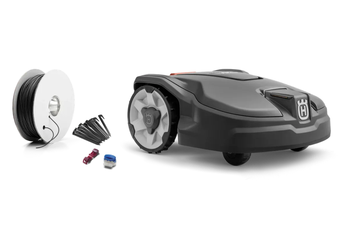 Seitenansicht eines Husqvarna Mähroboters mit Installationszubehör einschließlich Begrenzungskabel und Anschlussklemmen.