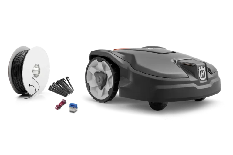 Seitenansicht eines Husqvarna Mähroboters mit Installationszubehör einschließlich Begrenzungskabel und Anschlussklemmen.